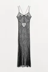 Vestido largo semitransparente de encaje negro, con escote en pico, tirantes finos dobles, abertura en la espalda y cierre con botones ocultos.