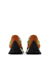 Championes New Balance de estilo casual, con capellada en tonos verde oliva, verde oscuro y naranja, con logo "N" en blanco y suela de goma negra.