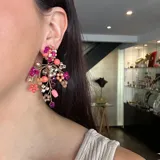 Aros colgantes hechos a mano con cristales rosas, fucsias, corales, plateados y violetas, unidos con alambre dorado.