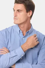 Camisa celeste a cuadros con cuello abotonado, manga larga, bolsillo en el pecho y logo bordado.