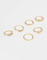 Set de seis anillos dorados con diferentes diseños: corazón, strass, hoja, moño, flor y trenzado.