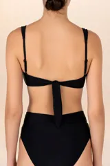 Top de bikini bandeau negro con corte circular y aberturas con cuentas doradas al centro. Breteles semi-amplios y ajustables en la espalda, con recogidos laterales.