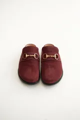 Mocasines tipo sueco de cuero gris con detalle de hebilla dorada.