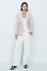 Blazer color rosa pálido de corte entallado y doble botonadura dorada.