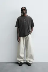 Pantalón de jean negro de corte amplio, estilo balloon fit, con cinco bolsillos y cierre frontal con botones.