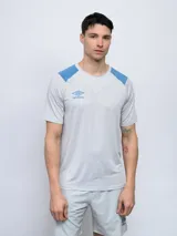 Remera de entrenamiento gris con detalles en azul en hombros y logo de Umbro en el pecho.