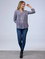 Camisa de gasa estampada con cuello a la base, escote en V, y apertura central con botones, presenta detalle plisado en la delantera.