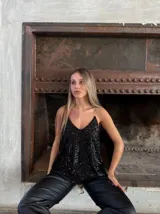Blusa de fiesta negra con lentejuelas, escote en V y tirantes finos.
