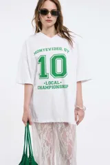 Remera color beige con cuello en V y estampado con la palabra 'Authentic' y una estrella.