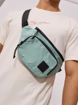 Riñonera negra de nylon arrugado con dos compartimentos con cierre y logo de la marca en relieve.