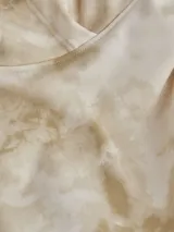 Buzo Calvin Klein de algodón con capucha y estampado tie dye en tonos beige y blanco. Tiene puños y dobladillo de punto canalé y logo CK estampado en el pecho.