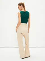 Pantalón gris oscuro de corte amplio, con pinzas en la cintura y bolsillos laterales.