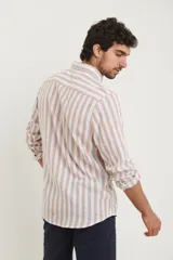Camisa de lino a rayas verticales azules y blancas, de manga larga con puños abotonados y cuello clásico.