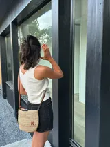 Bandolera de rafia natural con detalles en cuero, tejido de crochet y forro.