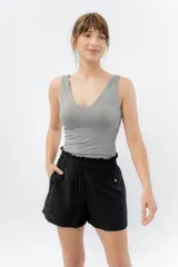 Musculosa gris de tela suave con escote en V en ambos lados y calce al cuerpo.
