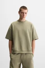 Sudadera negra de corte relaxed fit, confeccionada en tejido interlock de algodón con elasticidad. Tiene cuello redondo, manga corta y bajo acabado en rib.