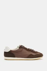 Zapatilla deportiva marrón con detalles en gamuza y talón en cuero sintético blanco.