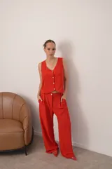 Conjunto de dos piezas color azul eléctrico, compuesto por un chaleco de manga corta con escote en V y botones frontales, y un pantalón de tiro alto con pierna ancha y pliegues.