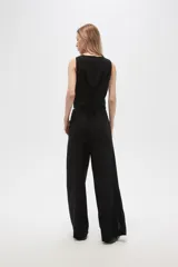 Pantalón negro ancho de lino y viscosa, de tiro alto y corte palazzo con aberturas en el ruedo.