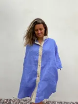 Vestido camisero celeste de lino con cuello mao, corte recto, mangas tres cuartos y cierre frontal con botones.