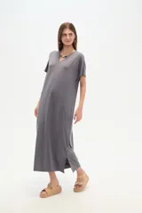 Vestido midi negro de poliéster, corte holgado, manga corta, cuello en V y detalle de cuentas en el escote.