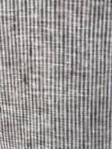 Camisa beige a rayas verticales finas, con cuello clásico, mangas largas abullonadas con puños marrones y cierre frontal con botones.