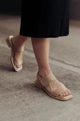 Sandalias bajas doradas de cuero, con punta cuadrada, tiras anchas y cierre con hebilla ajustable.
