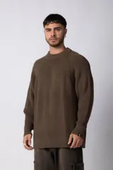 Sweater marrón de punto con cuello redondo y mangas largas raglán. Tejido grueso con textura acanalada. Corte holgado.