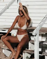 Conjunto de bikini blanco de lurex, con corpiño fijo y bombacha less.