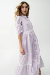 Vestido camisero midi color beige a rayas verticales, con cuello mao, mangas 3/4 abullonadas y festones de algodón en el cuerpo. Cierre frontal con botones.