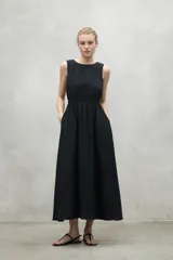 Vestido midi negro sin mangas, con cuello redondo, cintura elastizada y espalda abierta.