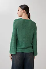 Sweater de punto color verde con cuello redondo y mangas largas.