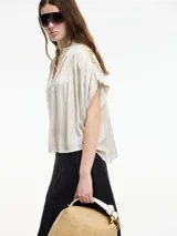 Blusa color crema de manga corta con bordados en la parte trasera.