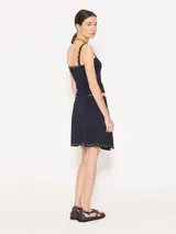 Pollera marrón tejida con calce al cuerpo, de largo arriba de las rodillas y detalle de tachas plateadas.