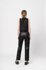 Pantalón de tiro alto negro de gabardina strech metalizada, con bolsillos y cierre frontal con cremallera y botón.