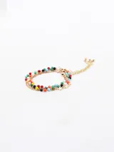Set de 4 pulseras en tonos vibrantes, con detalles dorados y diseño colorido.