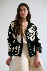 Chaqueta color crudo con bordados florales en tonos rojo, verde y negro.