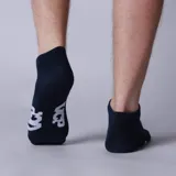 Medias invisibles blancas con logo negro en el tobillo. Ideales para usar con zapatillas y mantener un look discreto.