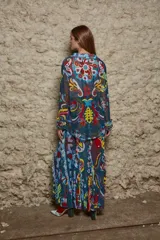 Camisa de tul elastizado con estampado paisley multicolor, corte clásico, cuello solapa, abotonada y con voladitos en las mangas. Similar a un talle M.