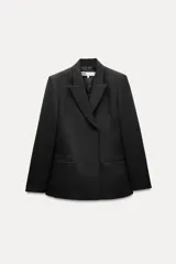 Blazer negro con cuello solapa de muescas y manga larga. Tiene falsos bolsillos de vivo en el delantero, forro interior a tono y cierre frontal cruzado con botón a presión.