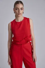 Conjunto de dos piezas color marrón, compuesto por un top sin mangas con volado en el ruedo y un pantalón ancho de tiro alto con volados decorativos a lo largo de las costuras laterales.