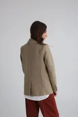 Blazer color camel de corte entallado, con solapas de muesca y cierre frontal con un botón.