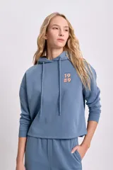 Canguro azul con capucha y cordones ajustables, con estampado de Sebastián el cangrejo de La Sirenita en la espalda.