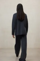 Sweater de tejido de punto color gris oscuro, con escote en V profundo y mangas largas amplias. El diseño es holgado y presenta aberturas laterales.