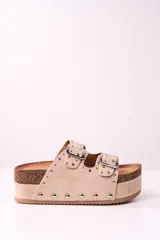 Sandalias beige con plataforma de corcho y doble tira con hebillas y tachas plateadas.
