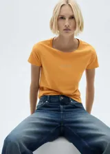 Camiseta blanca de algodón con logo 'Mango' estampado en dorado en el pecho.