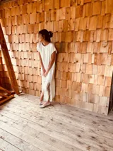 Vestido tejido color blanco con hilo metalizado, corte oversized, mangas cortas y flecos en el ruedo.