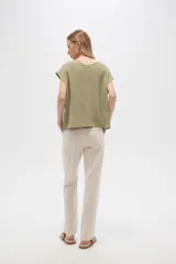 Pantalón de lino color verde oliva con estampado de flores color crema, de corte recto.