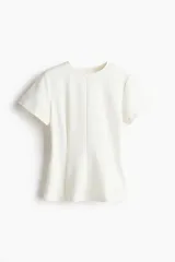 Remera blanca entallada de punto pesado interlock, con cuello redondo, mangas cortas, pinzas moldeadoras en la cintura y bajo acampanado.