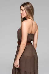 Vestido largo blanco, estilo maxi, sin tirantes (strapless) con parte superior elastizada y falda con volados escalonados.